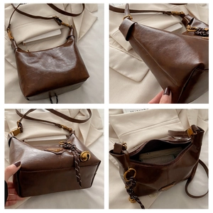 Detail view of vintage brown crossbody bag with metal logo and woven bell charm
