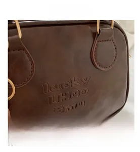 Detailed macro view of dark brown PU leather texture and embossed lucky lettering
