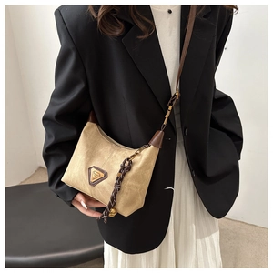 Detail of vintage suede shoulder bag with brown leather trim and woven cord accessory