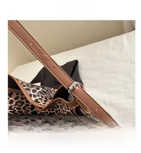 Detail showing the adjustable leopard print tote bag strap with silver metal buckle