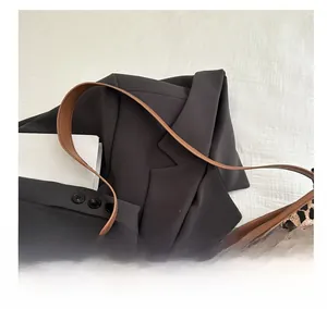 Detailed close-up of leopard print tote bag fabric with premium brown leather strap