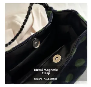 Detail of metal magnetic snap closure and woven handle on the plush polka dot tote bag