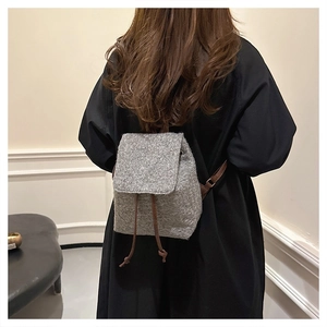 Detailed view of the wool-like mini backpack texture with brown drawstring and shoulder straps