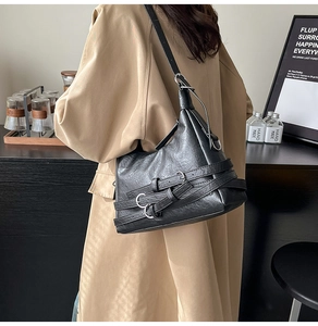 Close-up of black retro motorcycle tote bag featuring leather straps and silver buckles