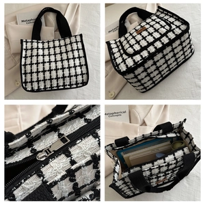 Detail view of tweed checkerboard tote bag showing zipper hardware and interior capacity