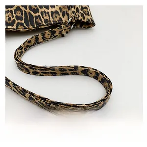 Detail of the leopard print tote bag showing the slim shoulder strap and leather texture