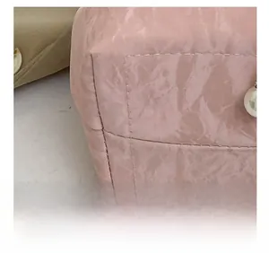 Gros plan sur les coutures de précision et le cuir rose texturé au bas du sac à main
