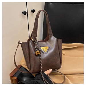 Detailed macro view of dark brown vintage texture PU leather bag with golden logo