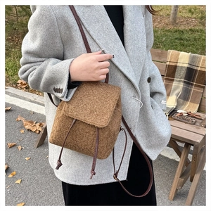 Close-up of brown plush mini backpack with drawstring closure and leather straps