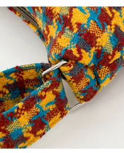 Macro shot of colorful tweed fabric texture and silver metal ring buckle on handbag