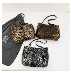 Detailed overhead view of three large leopard print tote bags in yellow, brown, and grey