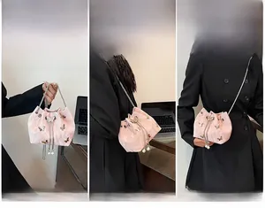 Détails du sac seau en satin rose montrant les styles porté main, épaule et bandoulière