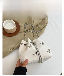 Détail du sac seau blanc avec cordon perlé et accents de papillons argentés