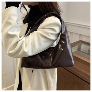 Macro-opname van de glanzende donkerbruine lakleren hobo tas met een spiegelende afwerking