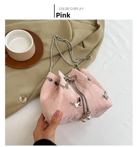 Sac bourse rose plissé avec charm nœud argenté et bandoulière en chaîne élégante