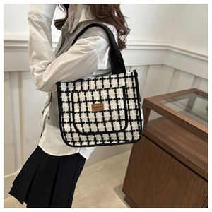 Detail of tweed checkered tote bag showing side pocket and Jingpin leather badge