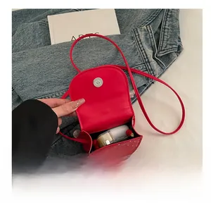 Detail view showing interior capacity and magnetic closure of the red polka dot mini bag