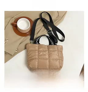 Detail of khaki quilted tote bag featuring padded fabric and stylish detachable black strap