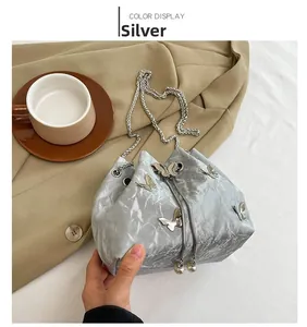Détails du sac bourse argenté plissé avec papillons en métal et cordon perlé