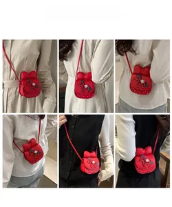 Model wearing a red girls crossbody bag with a large bow and horse embroidery detail