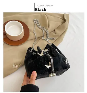 Détail du sac seau en velours noir avec papillons argentés et cordon de perles