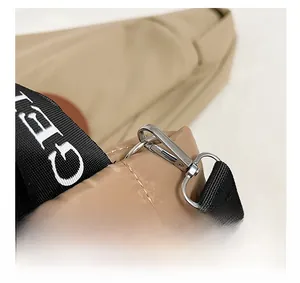 Close-up of silver hardware hook and wide printed strap on quilted khaki puffer bag