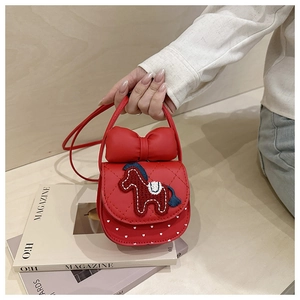 Close-up of red girls' crossbody bag with horse embroidery and large bow detail