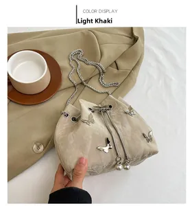 Vue détaillée du sac à cordon kaki clair avec papillon en métal et détails de perles