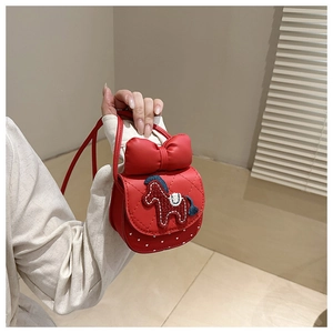 Detail of red girls' crossbody bag with bow, horse embroidery, and quilted PU texture