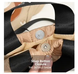 Detail view showing the secure snap button closure on this stylish quilted beige tote bag