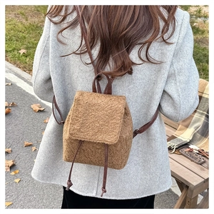 Detailed view of brown plush wool backpack with drawstring closure and soft texture
