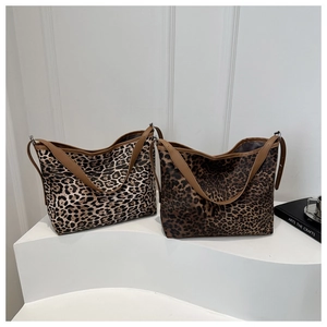 Detail of two leopard print tote bags in light beige and dark brown with leather handles