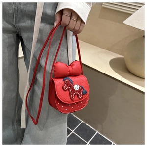 Close-up of red girls crossbody bag featuring 3D bow and pony embroidery detail