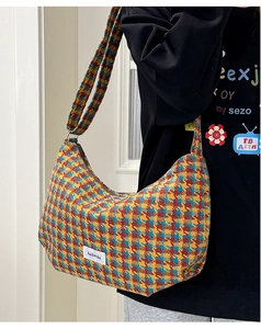Detailed close-up of a vintage plaid dumpling bag with vibrant hobo weave texture