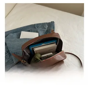 Vista interna della borsa in pelle marrone con spazio per tablet, ombrello e telefono