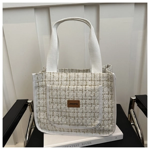 Detail of off-white tweed tote bag with woven texture and premium leather logo patch