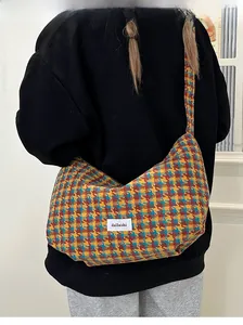 Detail of colorful houndstooth wool dumpling bag with stylish embroidered brand label