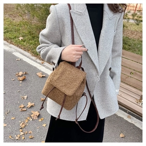Outdoor shot of a brown plush wool backpack with leather straps and drawstring closure