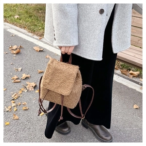 Detail of a brown plush mini backpack featuring soft faux fur and drawstring closure