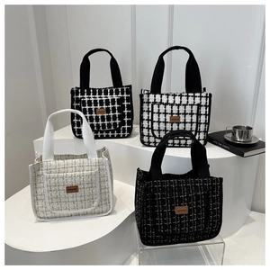 Detail of four tweed tote bags in various plaid patterns with leather logo labels