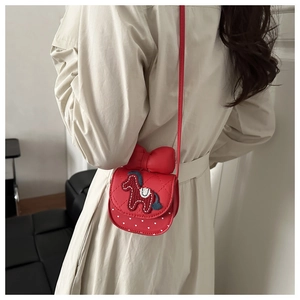 Detail view of red quilted mini crossbody bag with cute horse embroidery and bow decoration