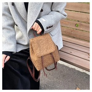 Detail of brown fuzzy wool texture on a mini backpack with leather drawstring straps