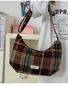 Close-up of retro brown plaid tweed shoulder bag with vintage texture and brand label