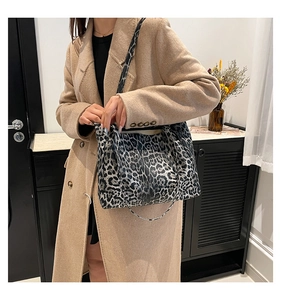 Lifestyle shot of a woman carrying a grey leopard print tote bag with a beige wool coat