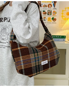 Close-up of brown plaid knitted dumpling bag featuring retro brand tag detail