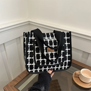 Chic black and white checkered tote bag with woven texture and comfortable handles
