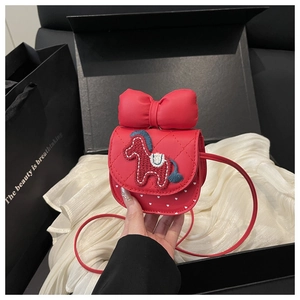 Detail of red girl's quilted crossbody bag with horse embroidery and a large bow