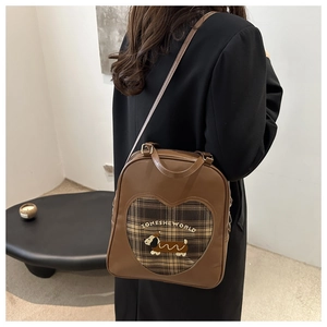 Dettaglio dello zaino vintage marrone con ricamo di cane e finestra a forma di cuore