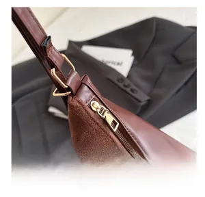 Detail shot of smooth zipper and suede texture on deep brown vintage shoulder bag