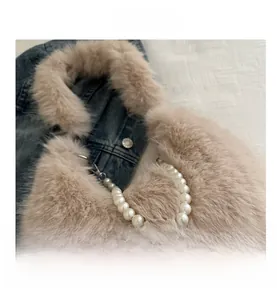 Détail du sac à main en fausse fourrure beige avec anse élégante en perles blanches